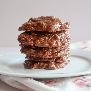chocolate peanut butter no bake cookies stacked on a plate.