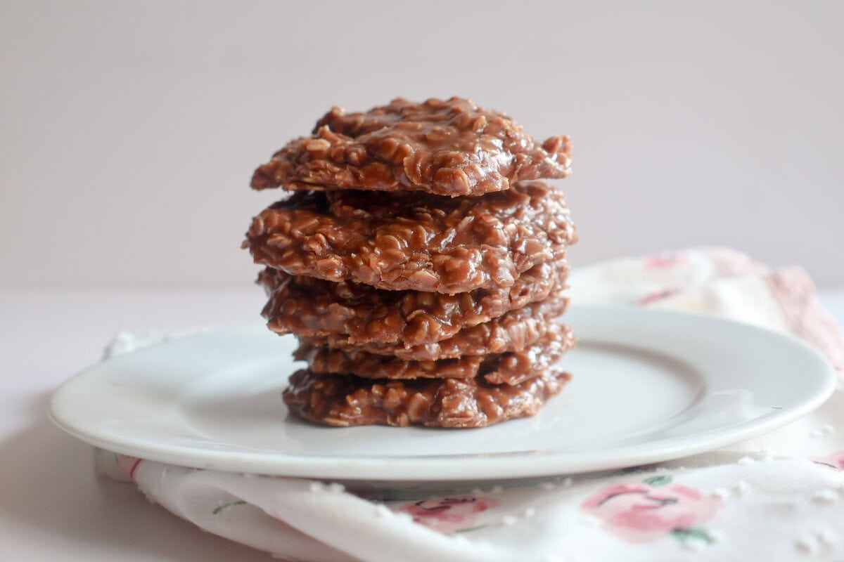 chocolate peanut butter no bake cookies stacked on a white plate.