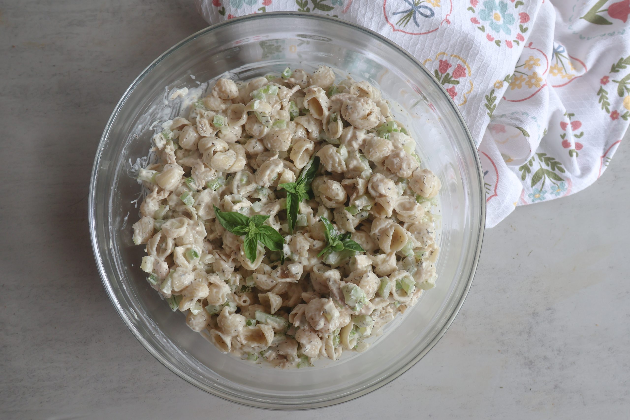 Creamy Tuna Pasta Salad in a glass bowl with a tea towel.