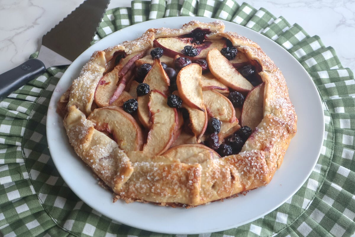 Blueberry Peach Galette on a white plate with a green and white placemat.