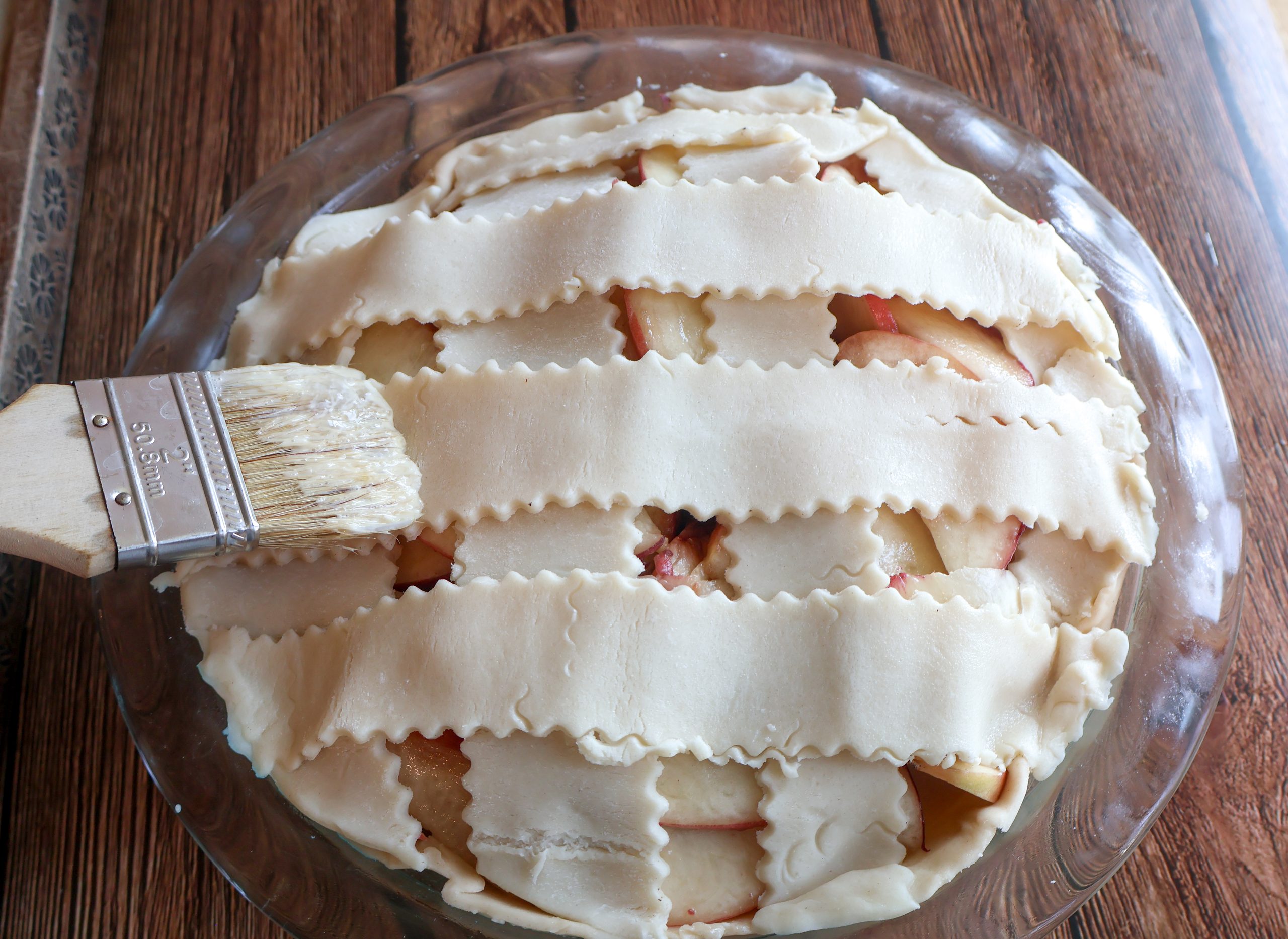 Brushing the pie with egg wask.