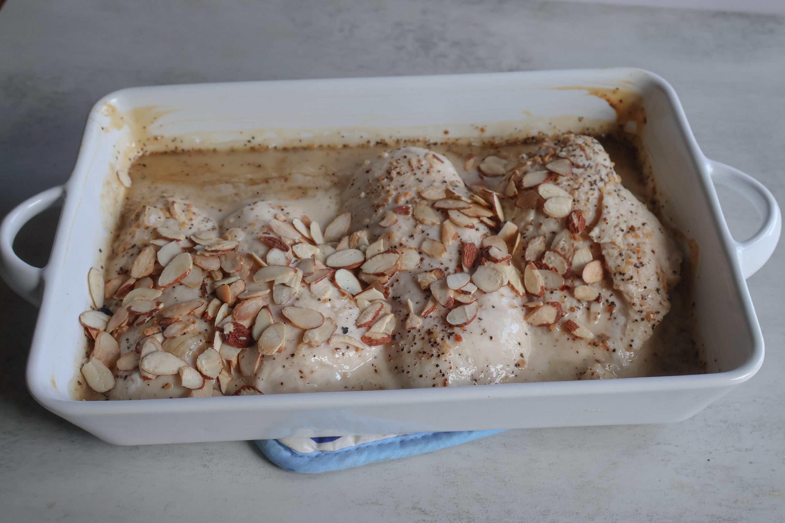 Baked Vidalia Onion almond chicken in a white casserole dish.