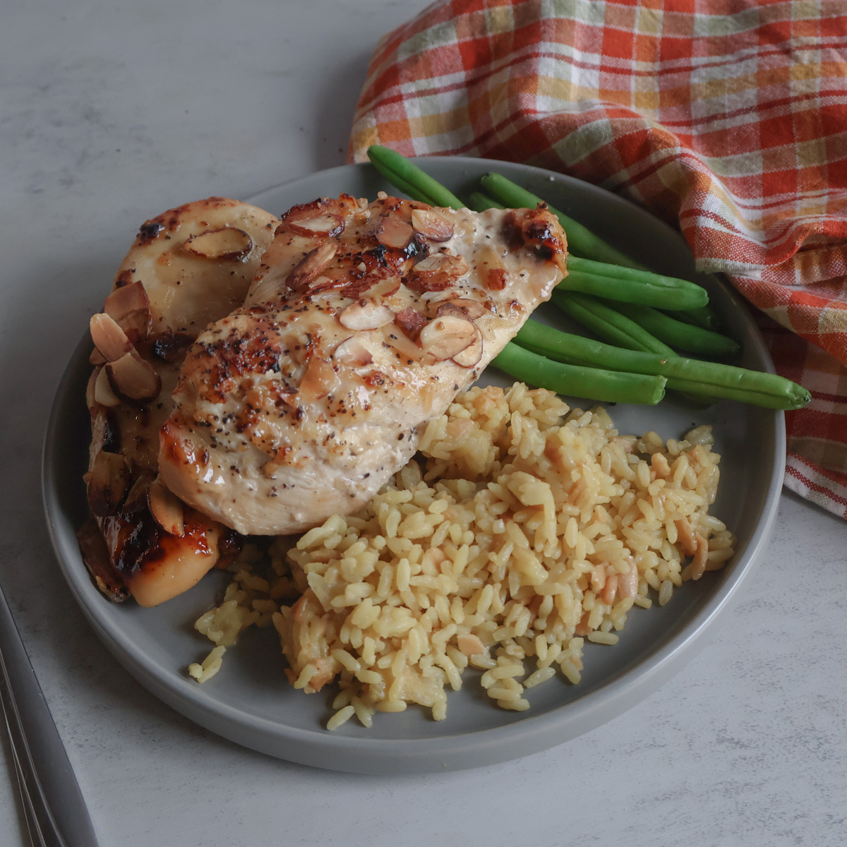 vidalia onion almond chicken with green beans, rice and a tea towel.