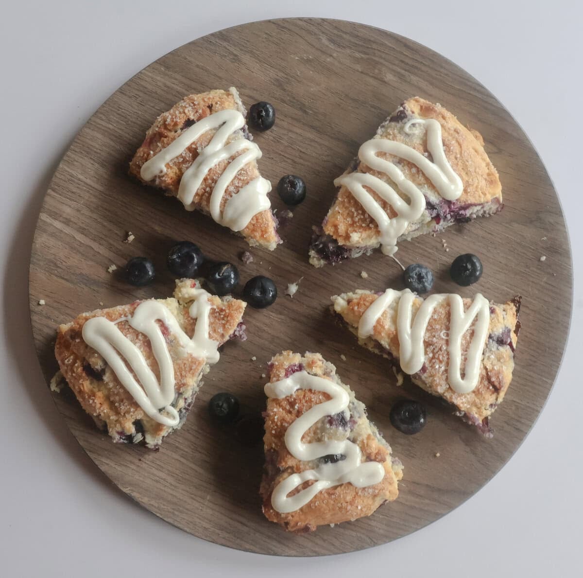 Blueberry white chocolate scones on a brown plate.