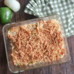 Baked chicken salad with rice with pepper, onion, and green and white napkin.