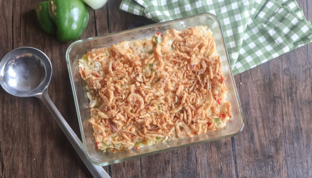 baked chicken salad with a serving spoon and green and white napkin.
