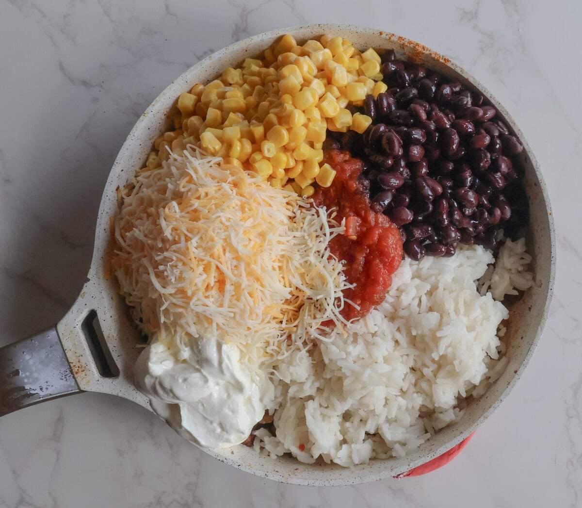 Corn, beans, rice, sour cream, cheese, and salsa mixed in with ground beef.