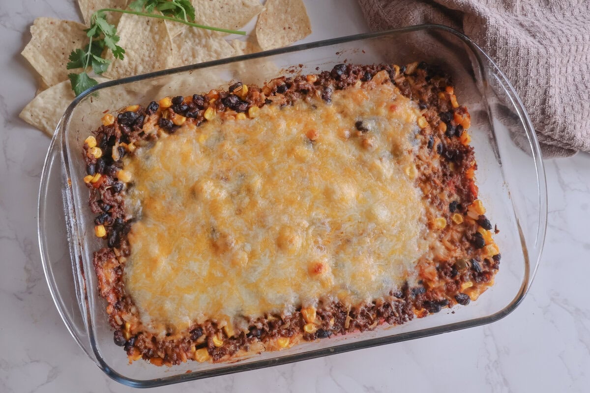 Easy cheesy mexican beef and rice casserole in a glass baking dish with tortilla chips.