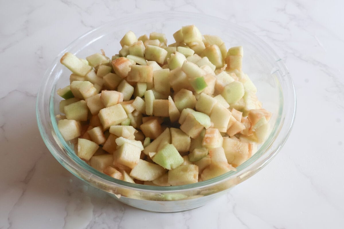 chopped apples in a glass bowl with lemon juice.