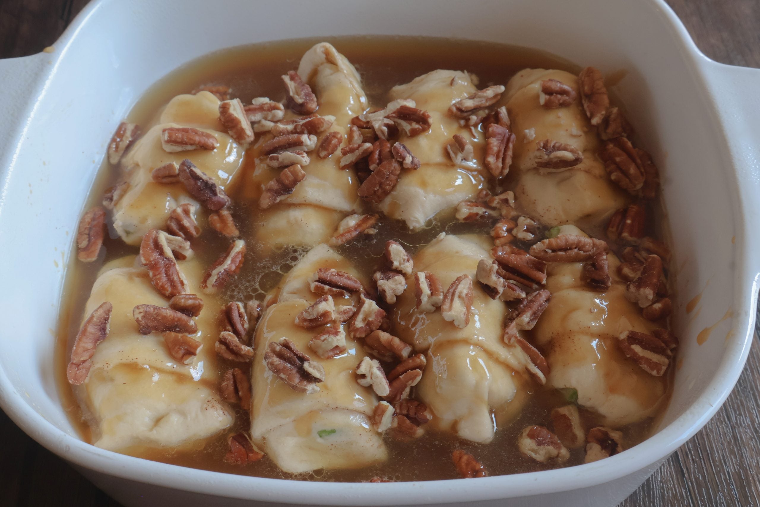 caramel apple dumplings with pecans on top.