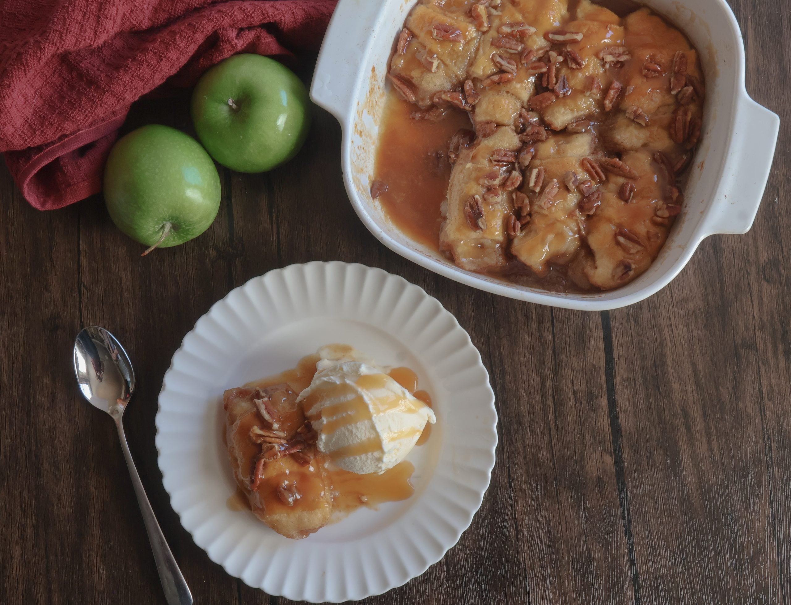 caramel apple dumplings in a white dish and on a white plate with fresh apples.