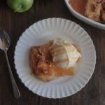 easy caramel apple dumplings with ice cream on a white plate with a fork.