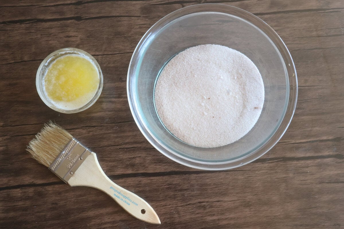 cinnamon sugar mix in a bowl with butter and a pastry brush.