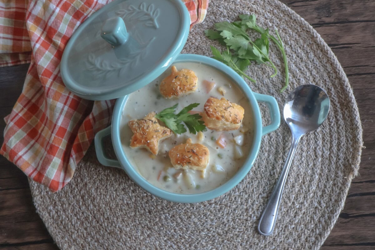 creamy chicken pot pie soup with puff pastry croutons and fresh parsley.
