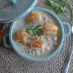creamy chicken pot pie soup in a blue crock with puff pastry croutons
