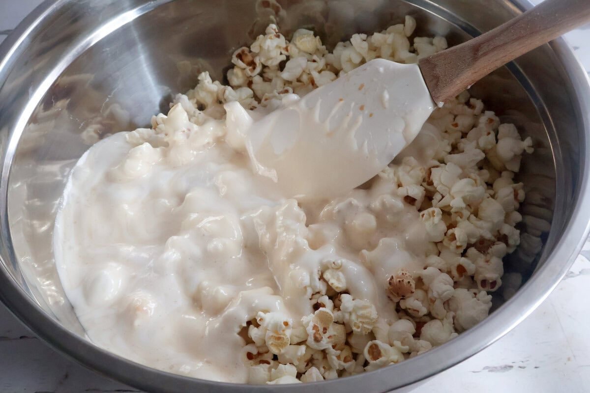 marshmallow mix being added to the popcorn.