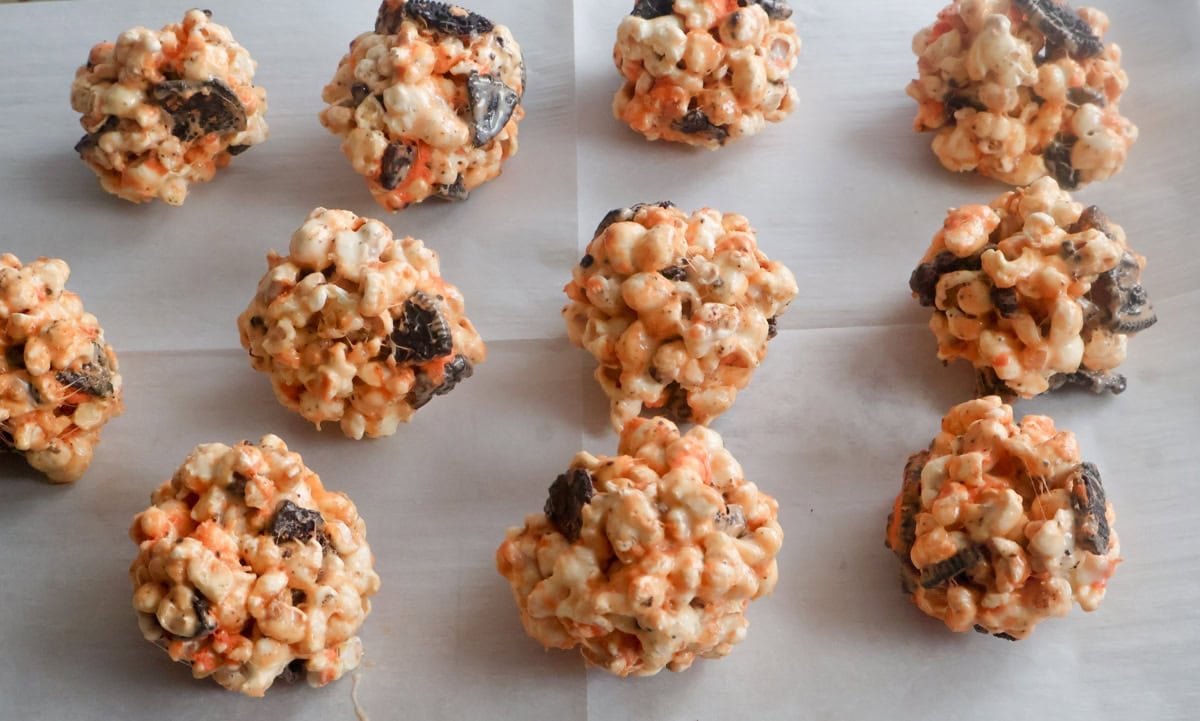 cookies and cream popcorn balls on a sheet pan.