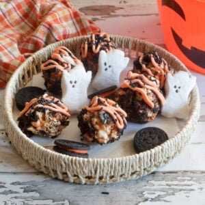 cookies and cream popcorn balls on a platter with ghost peeps.