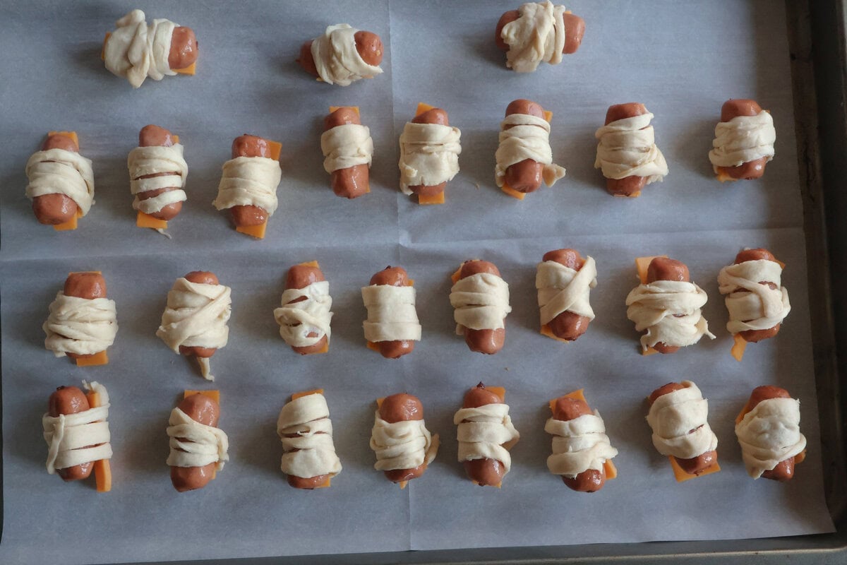 mini mummy hot dogs on a sheet pan.