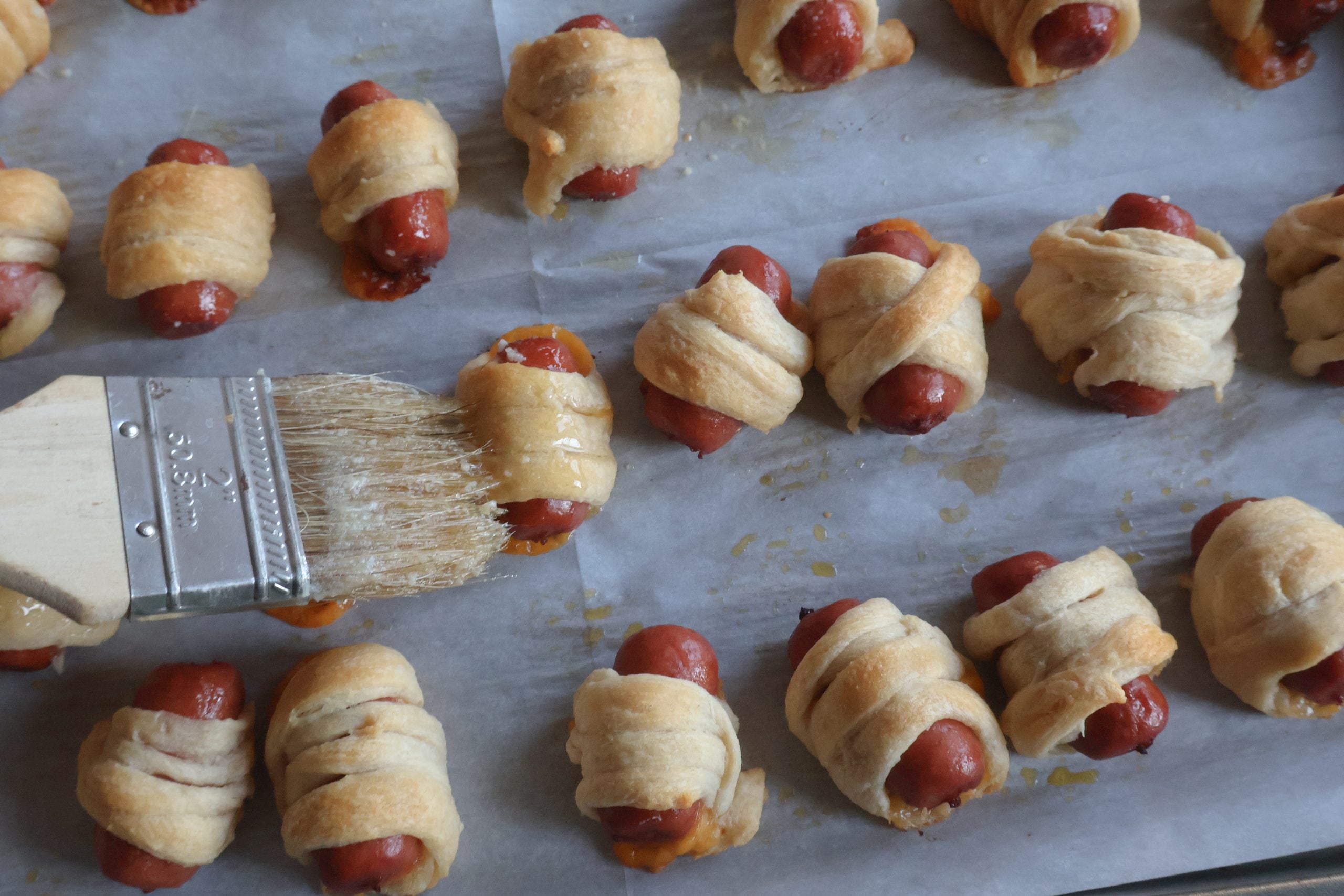 mini mummy hot dogs with garlic butter mixture.